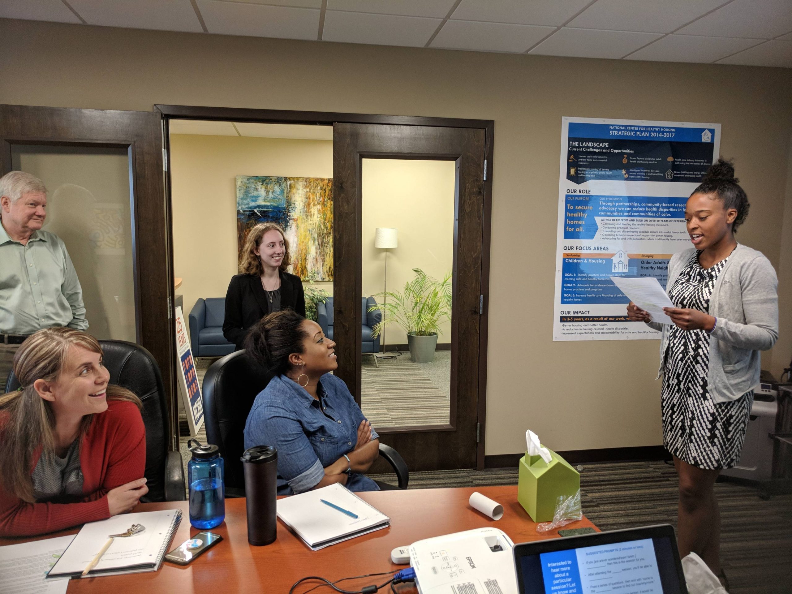 Woman giving a presentation to a small audience.